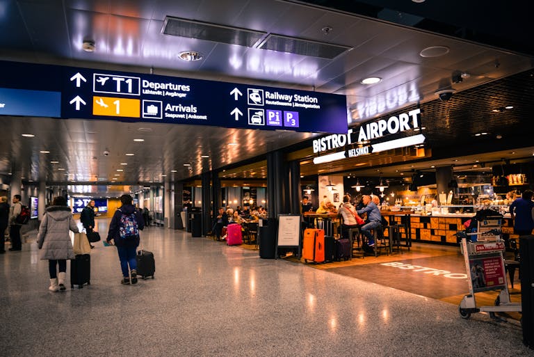 Travelers at Helsinki Airport dining and shopping near departures and arrivals.