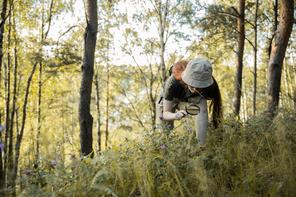 Photo by KATRIN BOLOVTSOVA Lapsi tutkii luontoa suurennuslasilla - luonnon tutkiminen lasten kanssa